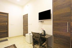 a room with a table and a television on a wall at Hotel Blist villa in New Delhi +3 photos