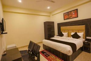 a bedroom with a bed and a desk and a television at Hotel Blist villa in New Delhi