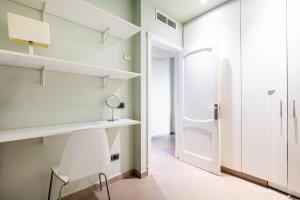 een kamer met een stoel, een bureau en een deur bij LUXURY HOLIDAYS SUITES, Playa de los Cristianos in Los Cristianos +107 foto's