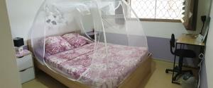 a bedroom with a bed with pink sheets and a window at Chez Marino & Charlie in Le Lamentin
