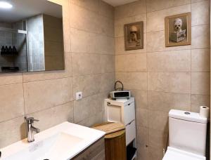 a bathroom with a sink and a toilet and a mirror at Apartment in 5 Mares development in Puebla de Farnals +8 photos