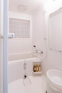 a white bathroom with a tub and a sink at 頤和小屋 in Osaka +61 photos