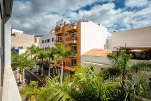 een uitzicht op een stad met palmbomen en gebouwen bij LUXURY HOLIDAYS SUITES, Playa de los Cristianos in Los Cristianos