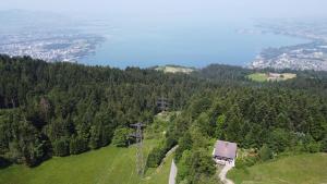 an aerial view of a hill with a house on it at Gasthaus Moosegg in Lochau