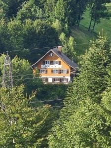 a house in the middle of a hill with trees at Gasthaus Moosegg in Lochau