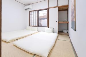 a room with two beds and a window at 頤和小屋 in Osaka