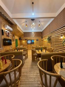 a restaurant with wooden floors and tables and chairs at Kasai in Dodoma +2 photos