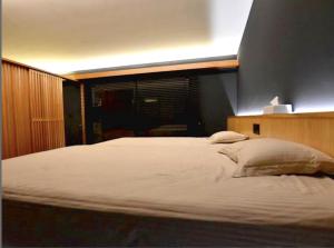 a bedroom with a large white bed with a window at Ryukyu Garden in Nanjo