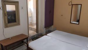 two beds in a room with a mirror and a table at Hotel Vijaya in Mau