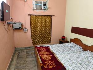 a bedroom with a bed and a window at Hotel Vijaya in Mau