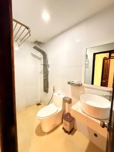 une salle de bain avec toilettes et lavabo dans l'établissement Vân Nhi MTV Hotel, à Đà Lạt