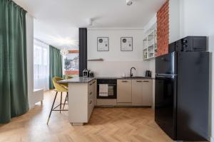 a kitchen with a black refrigerator and a table at Apartamenty Stojałowskiego 18 in Bielsko-Biala
