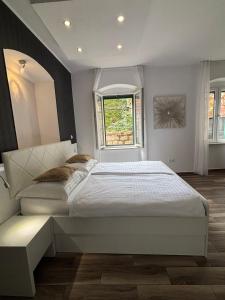 a bedroom with a large white bed and a window at Studio Apartman Fictilis in Split