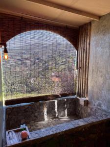 a window in a building with a view of a hill at Hobbit noi in Ban Huai Khai