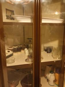a glass cabinet with dishes and other items in it at موني للشقق الفندقية in Qabāʼ