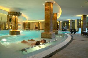 a woman laying in a swimming pool in a hotel at GPRO Valparaiso Palace & Spa in Palma de Mallorca