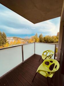 a balcony with two chairs and a view of trees at Triventi Apartament 2 sypialnie, garaż, blisko Tropikana i wyciąg na Kopę in Karpacz +10 photos