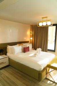 Un dormitorio con una cama grande con sábanas blancas. en Domaine RJ, en Kenitra