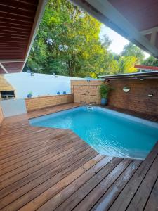 einen Pool auf einer Holzterrasse mit einem Pool in der Unterkunft Villa JOLIS 4 chambres avec piscine en Guadeloupe in Les Abymes