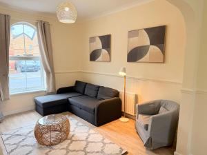 een woonkamer met een bank en een stoel bij Modern 4 bedroom property 8 beds wifi smart tv games room pool table in Hull