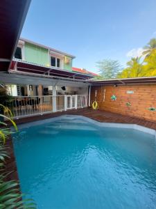 ein großer blauer Swimmingpool vor einem Haus in der Unterkunft Villa JOLIS 4 chambres avec piscine en Guadeloupe in Les Abymes