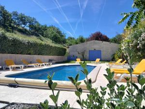 a swimming pool with lounge chairs next to a yard at Gîte Jasmin in Plavilla