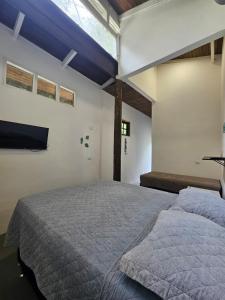 a bedroom with a large bed and a window at Mata em Mar - Chalé em Camburi in São Sebastião