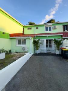 ein farbenfrohes Haus mit einer Einfahrt davor in der Unterkunft Villa JOLIS 4 chambres avec piscine en Guadeloupe in Les Abymes + 39 Fotos