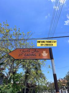 a street sign on a pole with a sign at Dmfamilyhomestay in Muar