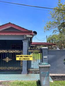 a yellow sign on the gate of a house at Dmfamilyhomestay in Muar