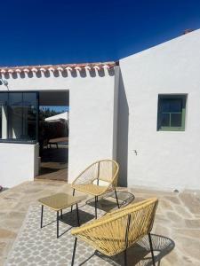 two chairs and a table in front of a building at La Parenthèse in L'Ile d'Yeu