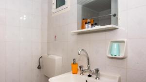 a white bathroom with a sink and a toilet at Olga Studios - 1 in Tsilivi