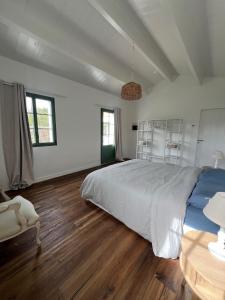 a bedroom with a large bed and a wooden floor at La Parenthèse in L'Ile d'Yeu
