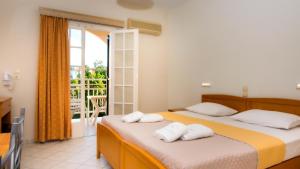 two beds in a room with a balcony at Olga Studios - 1 in Tsilivi