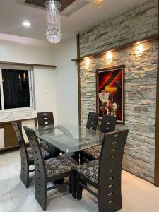 ein Esszimmer mit Glastisch und Stühlen in der Unterkunft 4 BHK Duplex Flat at Baner, Pune in Pune