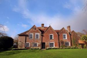 a large brick house on a green lawn at Wilksworth Caravan Park in Wimborne Minster
