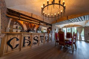 a dining room with a bar with a chandelier at Hotel Castel Suceava in Suceava