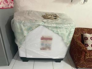 un récipient en plastique posé sur le sol à côté d'un canapé dans l'établissement 1 Bedroom Townhouse with Airconditon ,Water heater and free wifi,fully furnished, à San Roque