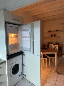 a kitchen with a washing machine and a table at Ostria spiti in Aígio
