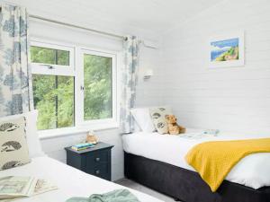 een slaapkamer met twee bedden en een raam bij Merley Woodland Superior4 Lodge with Hot Tub in Wimborne Minster