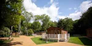 een kleine hut midden in een tuin bij Merley Woodland Superior4 Lodge with Hot Tub in Wimborne Minster