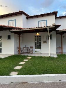 a white house with a picnic table in the yard at Ostria spiti in Aígio