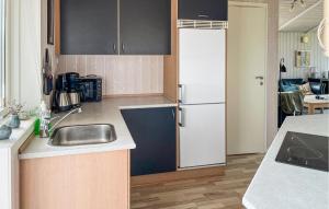 a kitchen with a sink and a refrigerator at Lovely Home In Hadsund With Sauna in Haslevgårde