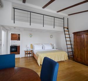a bedroom with a bed with blue chairs and a ladder at La Fenice in Prague