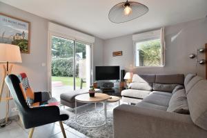 Le Vau PiardにあるLes 9 plages - Piscine privéeのソファとテレビのあるリビングルーム