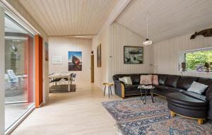 a living room with a leather couch and a table at Nice Home In Dronningmølle With Sauna in Firhøj