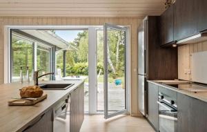 a kitchen with a large glass door leading to a patio at Nice Home In Dronningmølle With Sauna in Firhøj