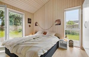 a large bed in a room with a large window at Nice Home In Dronningmølle With Sauna in Firhøj +17 photos