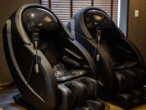two black leather seats in a room at Anshin Oyado Ginza Shimbashi Station - For Men in Tokyo