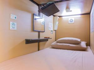 a room with a bed and a table and a mirror at Anshin Oyado Ginza Shimbashi Station - For Men in Tokyo +50 photos